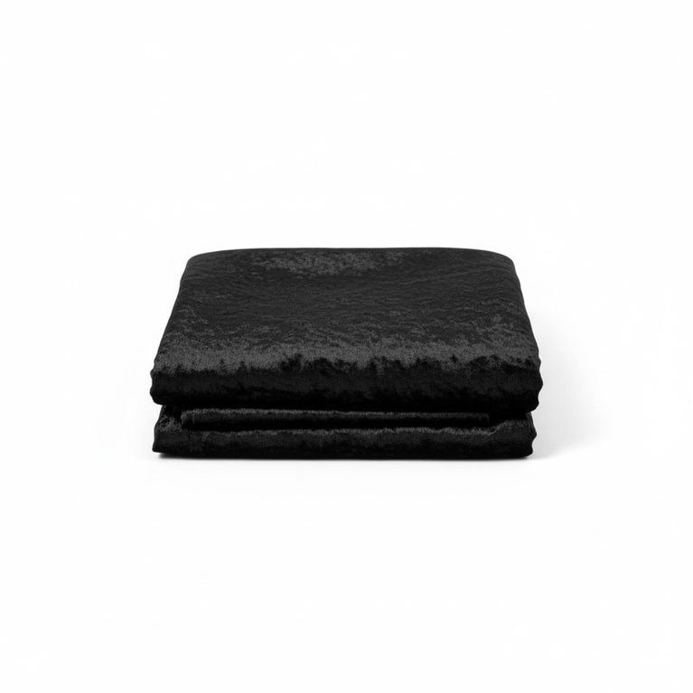 Stack of black velvet fabric on a white background