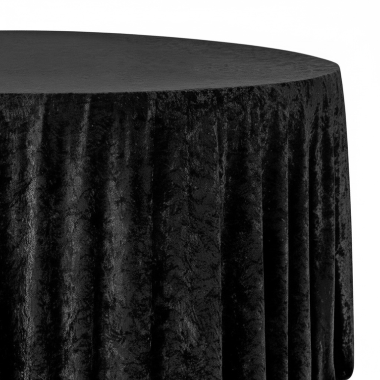 Black round velvet tablecloth on a round table with a plain background