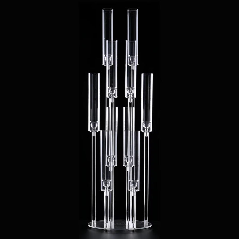 Clear acrylic candle holder with multiple cylindrical sections on a black background