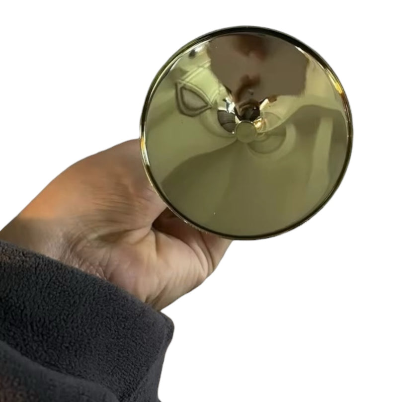 Gold-colored steel cup held by a hand on a white background