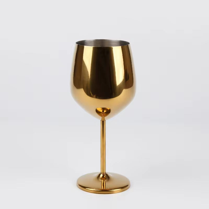 Gold wine glass on a light gray background