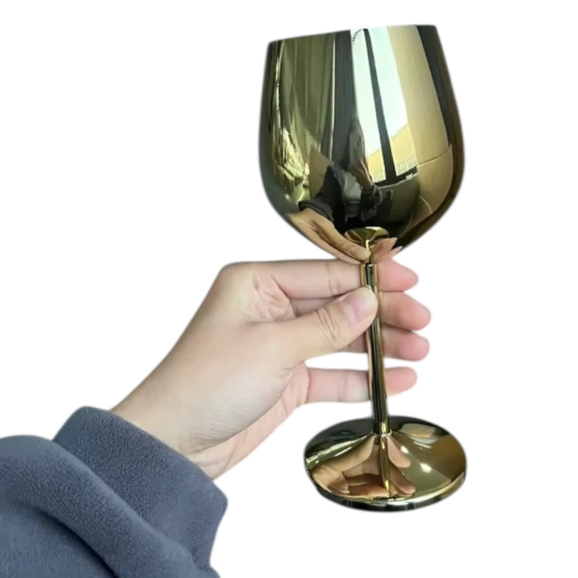 Gold wine glass held by a hand on a white background