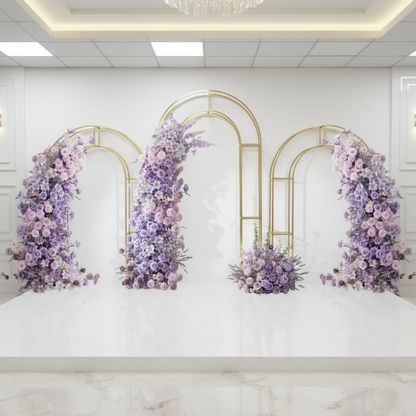 Decorative floral wedding backdrop arches with purple and pink flowers on a white marble wall.