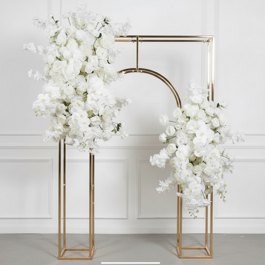 Gold wedding arch with white floral decorations against a white background
