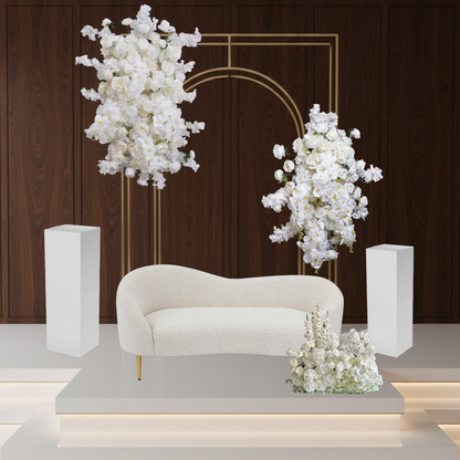 Decorative setup with a white sofa, floral wedding backdrop, and a wooden wall background