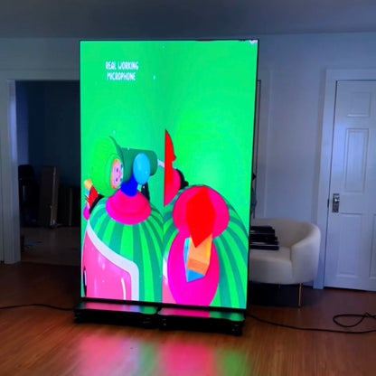 Large led screen displaying colorful abstract art in a room with a white door and wooden floor.