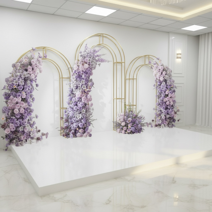 Decorative wedding floral arches with purple flowers in a room with white walls and marble floor.