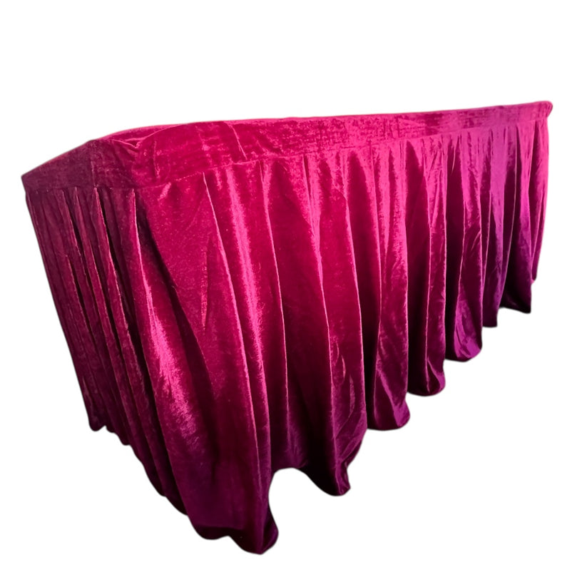 Burgundy velvet tablecloth draped over a table on a white background