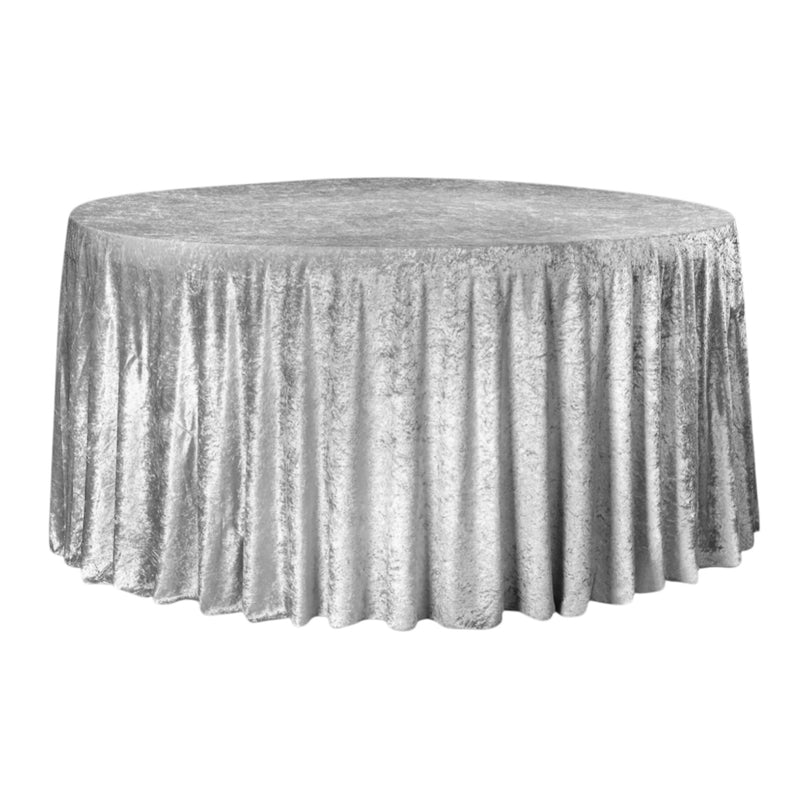 Round table covered with a silver velvet tablecloth on a white background
