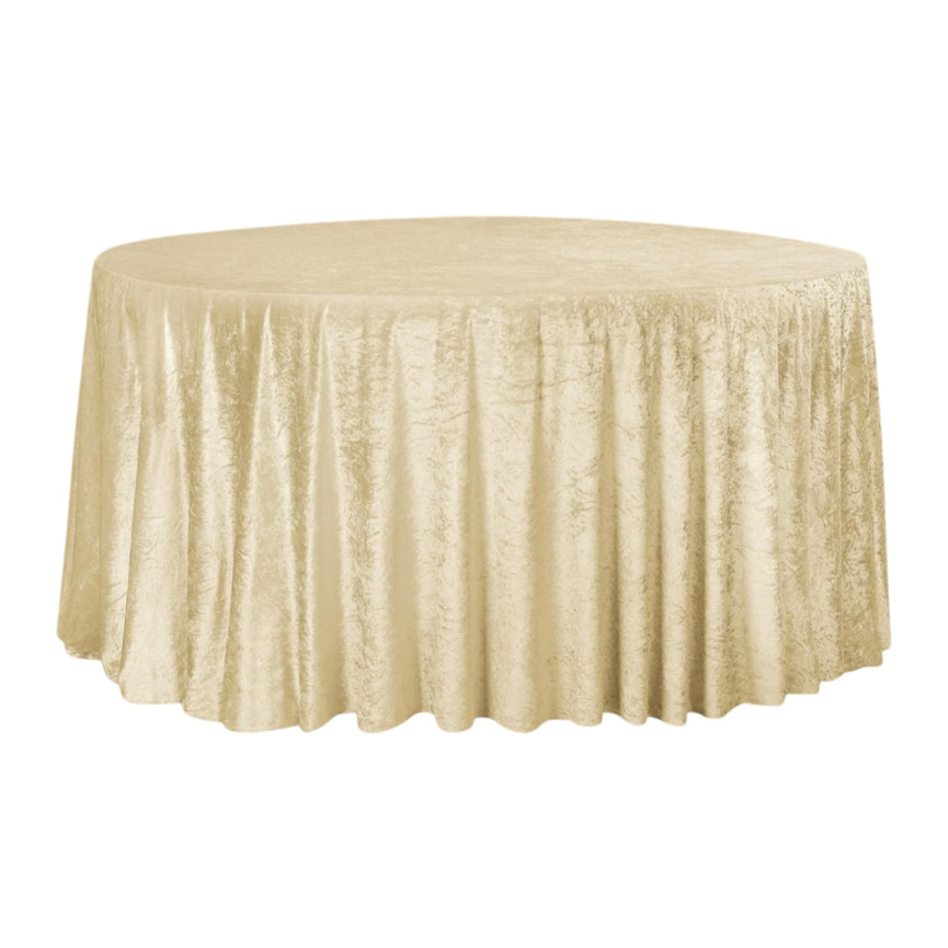 Round table covered with a champagne velvet tablecloth on a white background