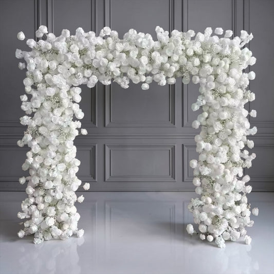 Floral arch made of white flowers against a gray wall