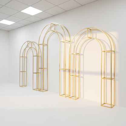 Set of gold arch-shaped wedding backdrops against a white wall.