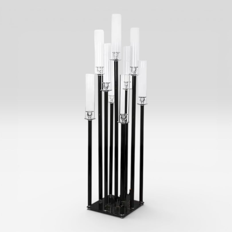Black metal candle holder with white candles on a gray background