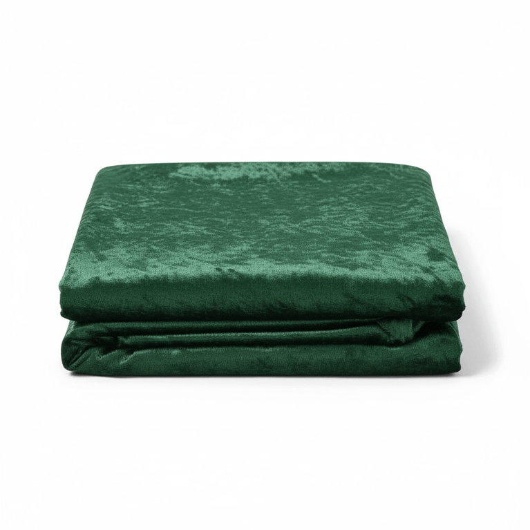 Folded emerald green velvet fabric on a white background
