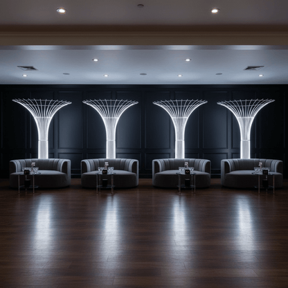 Modern lounge area with tall white tree props, gray sofas and decorative ceiling lights.