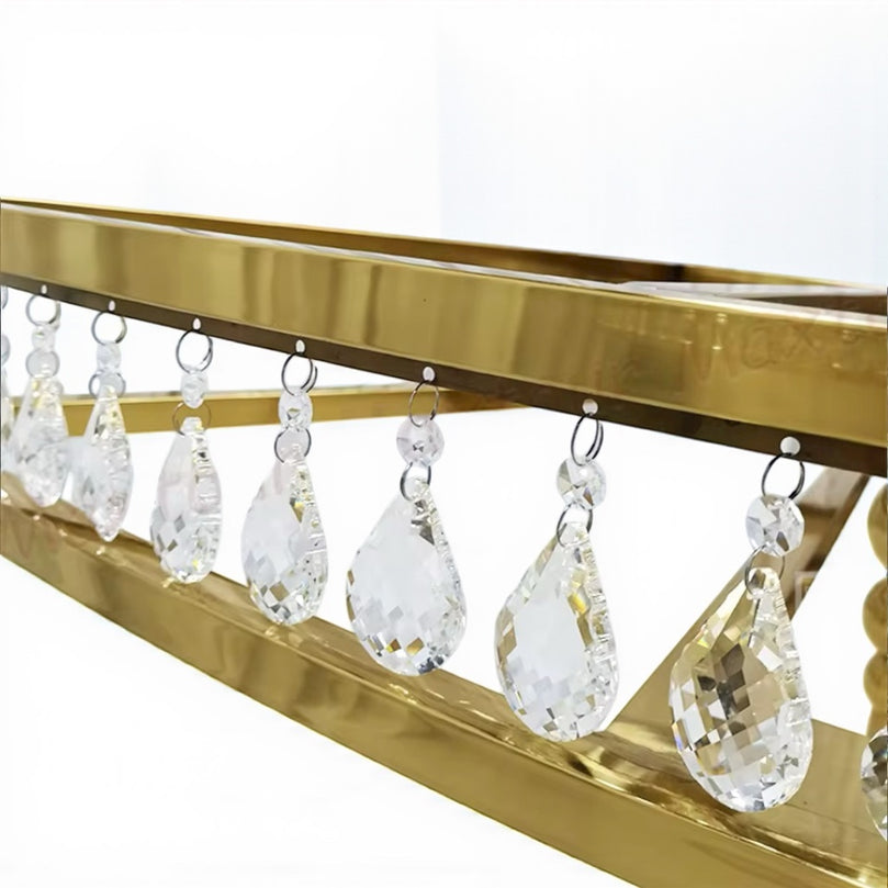 Gold decorative strip with crystal teardrop pendants on a white background