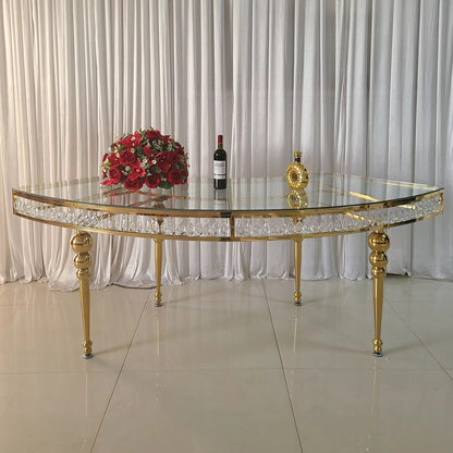Gold and glass table with decorative items against a white curtain background