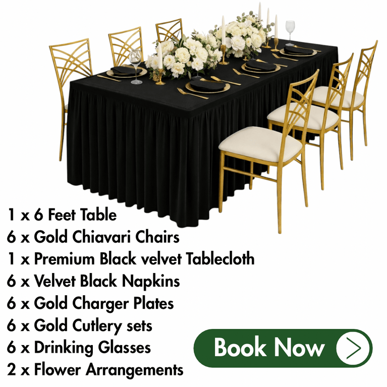 Table setting with black tablecloth, gold chairs, and white flowers on a white background.