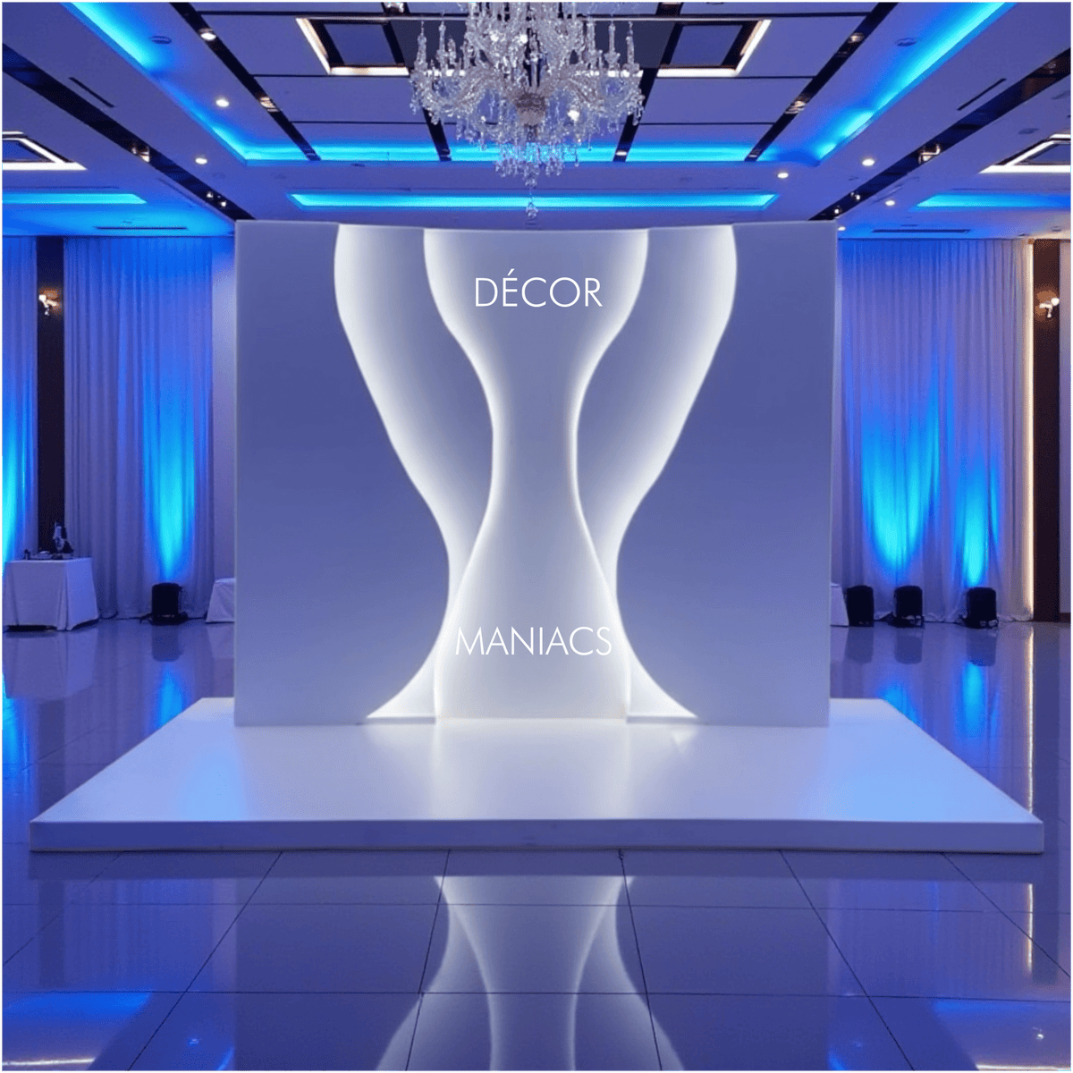 Decorative setup with a white backdrop arch and 'Décor Maniacs' branding in a room with blue lighting.