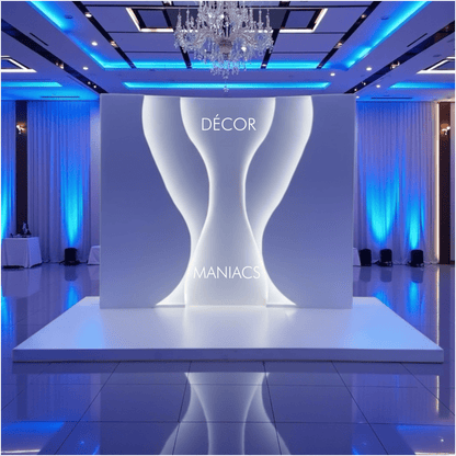 Decorative setup with a white backdrop arch and 'Décor Maniacs' branding in a room with blue lighting.