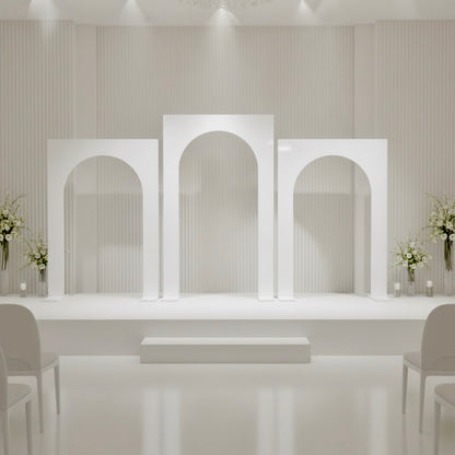 Modern interior design with white wedding arches and floral arrangements.