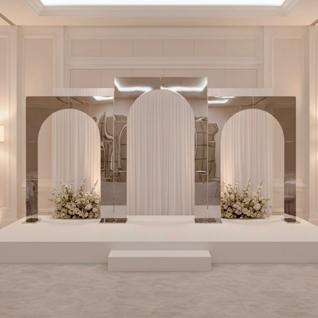 Modern interior design with silver wedding backdrop arches and floral arrangements.