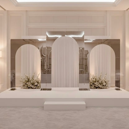 Modern interior design with silver wedding backdrop arches and floral arrangements.