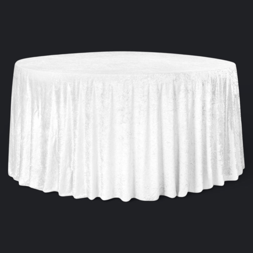 White round velvet tablecloth on a round table against a black background